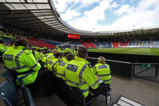 Police officers hold their pre-match team-talk