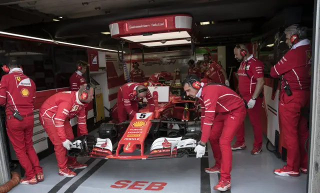 Mechanics work on Sebastian Vettel's car