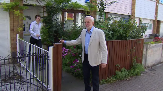 Jeremy Corbyn walking through a garden gate