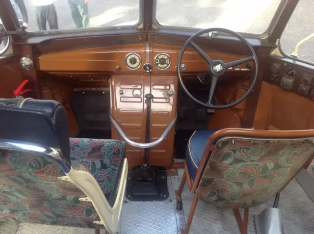 Interior of coach, showing dashboard and upright driver and passenger seats