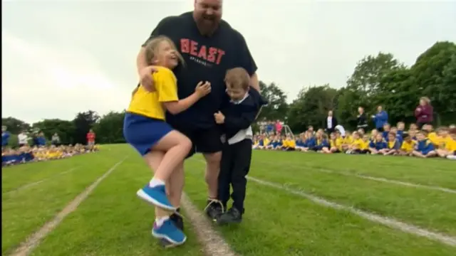 Eddie Hall at sports day carrying his children