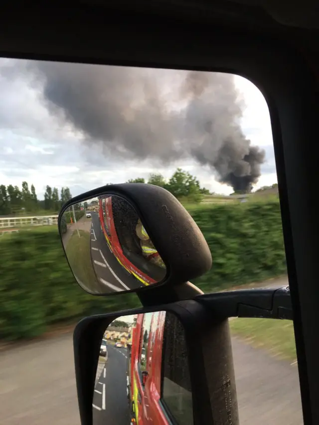 Smoke in distance as fire engines rush to scene