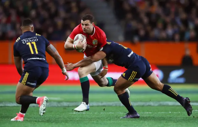 Robbie Henshaw of the Lions is tackled by Malakai Fekitoa