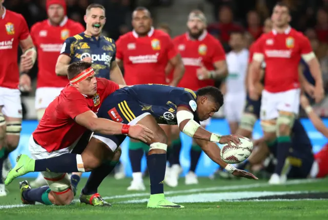 Waisake Naholo of the Highlanders barges through CJ Stander of the Lions to score the opening try