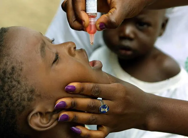 A medical staff vaccinates a child against polio