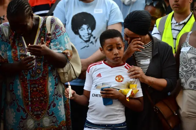 People hold candles at a vigil outside Notting Hill Methodist Church