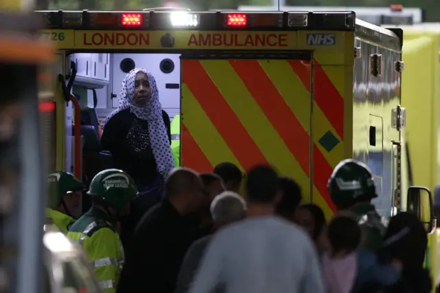 A resident stands in an ambulance by Grenfell Tower after it was engulfed by fire