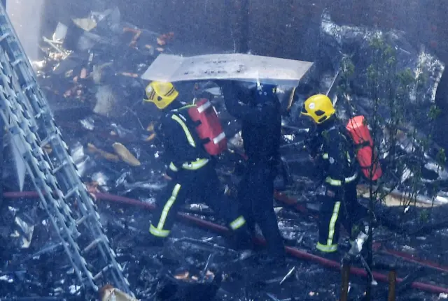 Firefighters continue to work on the fire in Grenfell Tower