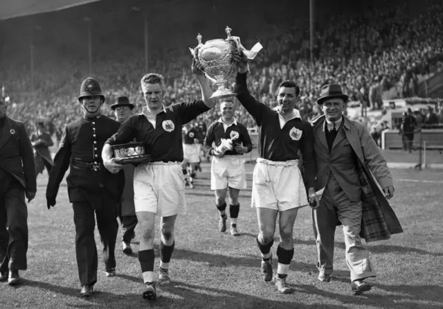 Salford skipper Gus Risman (right) and Harald Thomas carry the cup at Wembley