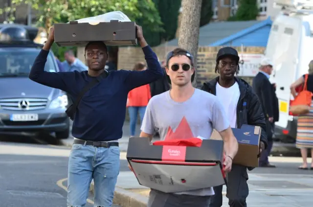 People bring donations to Rugby Portobello Centre after a fire engulfed Grenfell Tower in west London