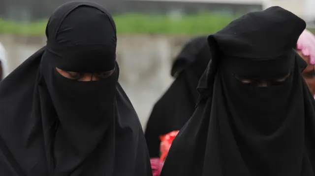 Muslim women wearing a niqab pray as part of the Eid al-Adha, also kown in Ivory Coast as the Tabaski, on October 15, 2013 in Adjame