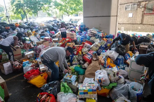 Volunteers sort through donations near to the scene of the Grenfell Tower fire