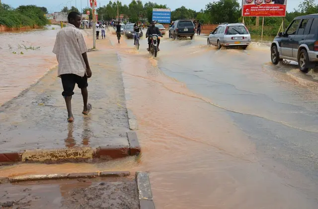 Vehicles use a flood-water covered road near the Niamey river in Niamey on August 21, 2012