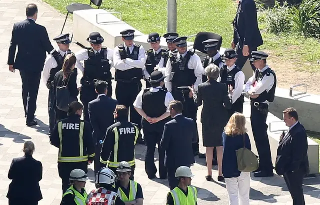 Prime Minister Theresa May speaks to police officers as she visits the scene near Grenfell Tower in west London