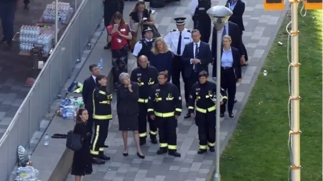 Theresa May speaks to fire commissioner Dany Cotton during a brief visit to the scene