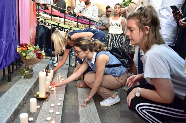 People light candles as people gather for prayers outside the Notting Hill Methodist Church, after a fire engulfed Grenfell Tower in west London.