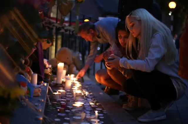 People light candles as they observe a vigil outside Notting hill Methodist Church following the blaze at Grenfell Tower, a residential tower block in west London on June 15, 2017