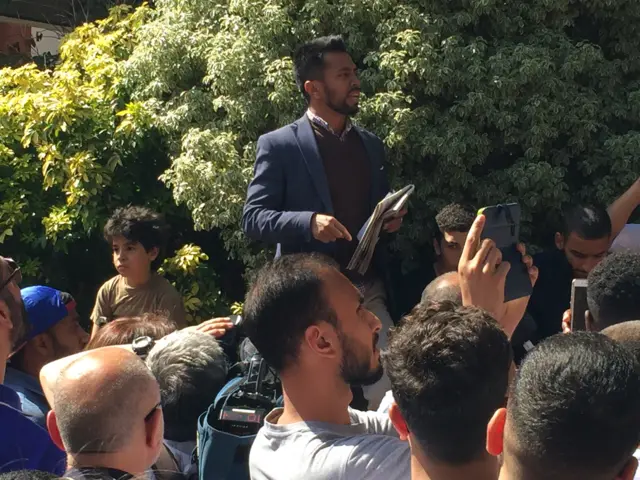 A protest organiser addresses the crowd outside Kensington and Chelsea town hall