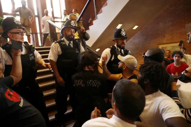 Police standing on the stairwell in Kensington Town Hall