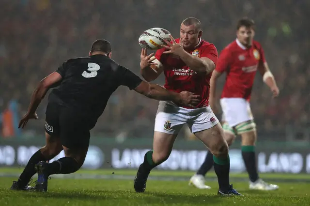 Jack McGrath of the Lions receives the ball under pressure from Ben May of the Maori All Blacks