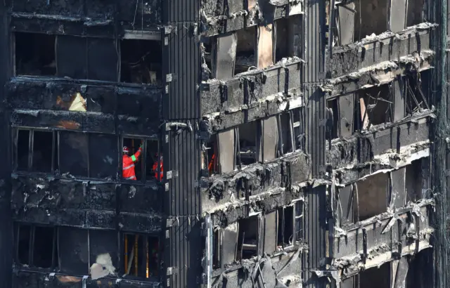 Members of the emergency services work inside the ruin of Grenfell Tower, 18 June