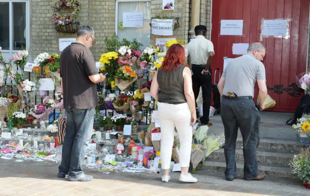 People lay flowers outside Notting Hill Methodist Church near to Grenfell Tower, 18 June