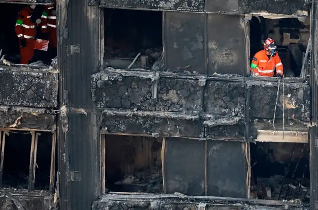 Members of the emergency services work on the middle floors of the Grenfell Tower block