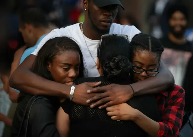 People comfort each other outside Notting hill Methodist Church