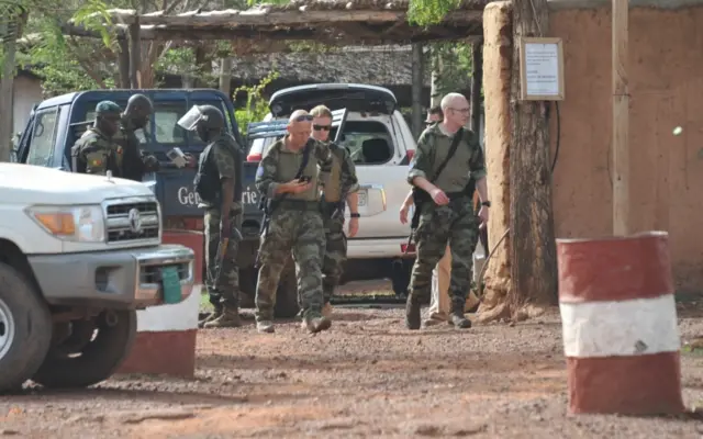 European and Malian forces walk at the entrance of the Kangaba tourist resort on the edge of Bamako on June 19, 2017, a day after suspected jihadists stormed the resort, briefly seizing more than 30 hostages and leaving at least two people dead.