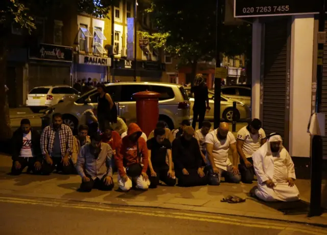 A group of Muslim men prayed on the street in the aftermath.