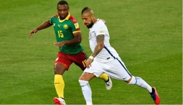 Cameroon's Sebastian Siani (left) battles for the ball with Chile's Arturo Vidal