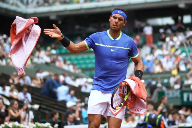 Rafael Nadal gives a towel back