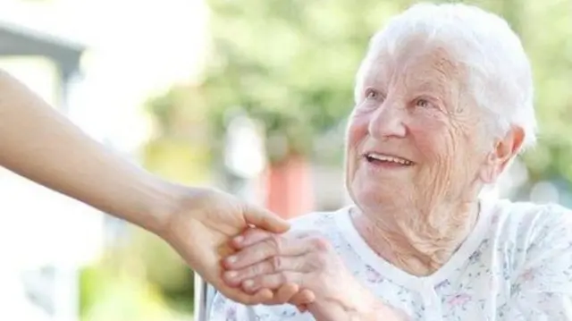 Older person holding hand with relative