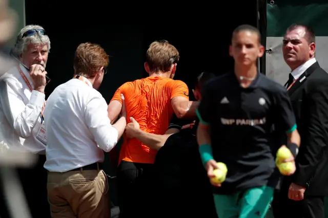 David Goffin is helped off court