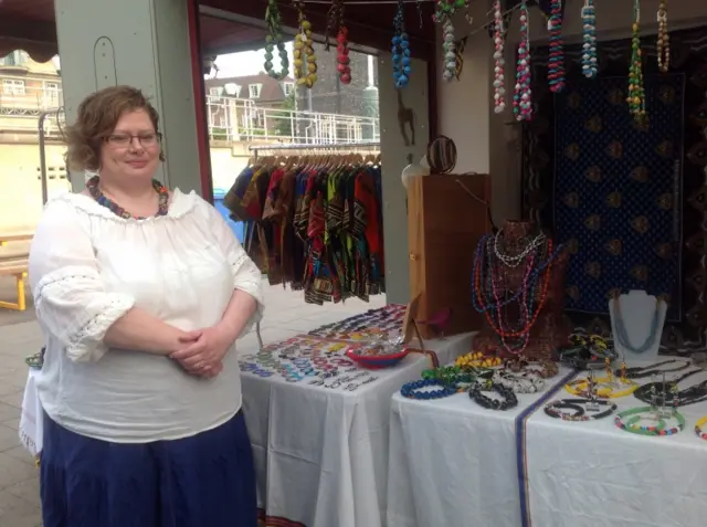 Sophie standing by her market stall, with jewellery on display