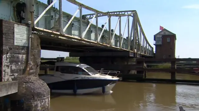 Broads cruisers passing under swingbridge