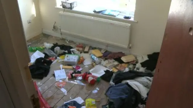 Rubbish strewn over bare floorboards