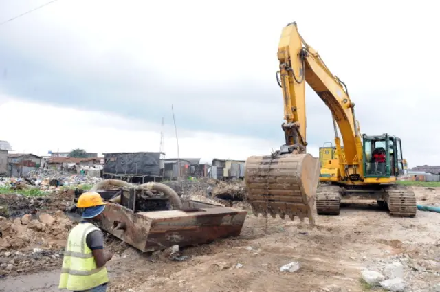 A state caterpillar tries to grade with sand areas where residents were evicted at Badia East slums in Lagos on August 12, 2013