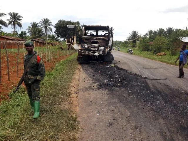 A Congolese boy stands next to a United Nations vehicle burned during a ambush in the eastern town of Beni on May 5, 2015