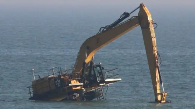 Excavator stranded in the sea