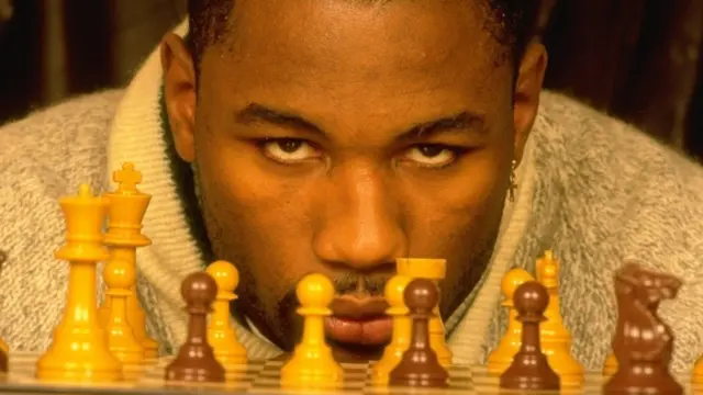 1992: Portrait of Heavyweight boxer Lennox Lewis of Great Britain playing chess.