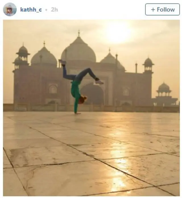 Woman doing a handstand with the Taj Mahal in the background