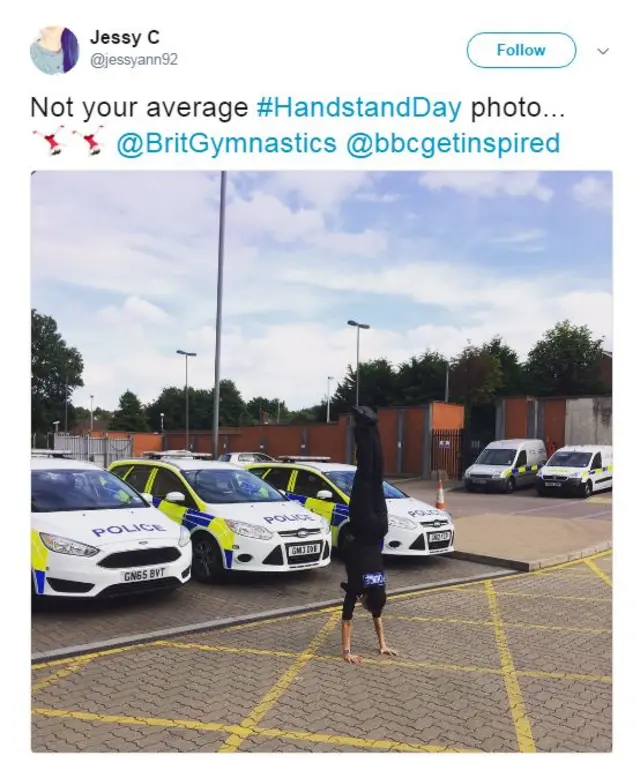 Police woman performing a handstand at a police station car park