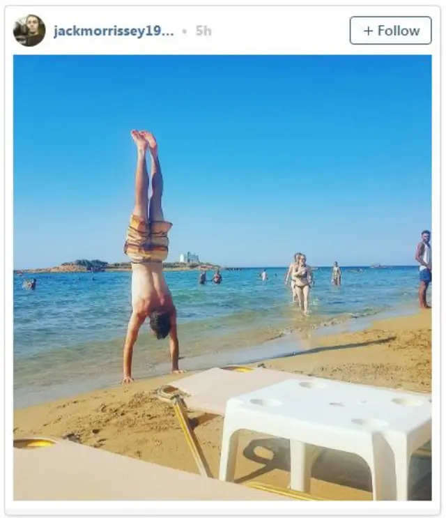 Man performing a handstand on the beach on Crete