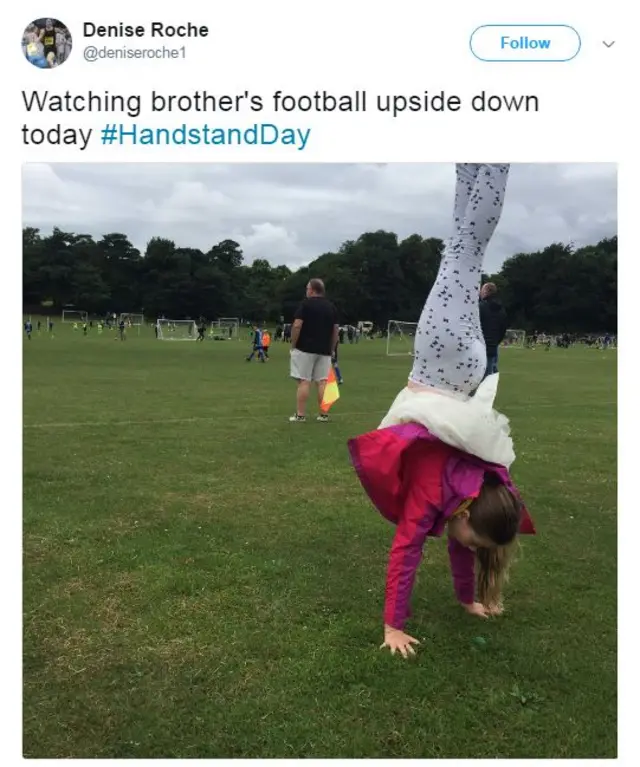 Girl performing handstand while watching a local football game