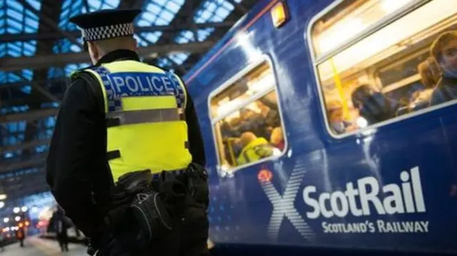 Police officer standing next to train