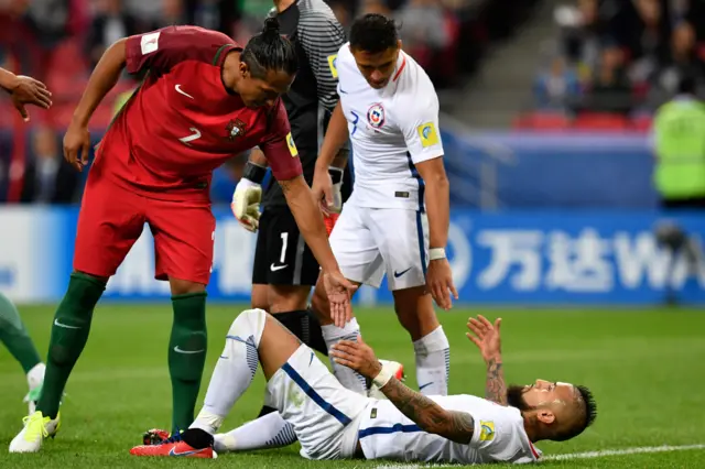 Bruno Alves helps Chile's Arturo Vidal up