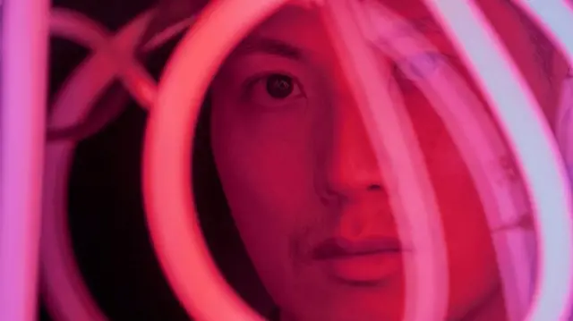 Man looking through loops of light