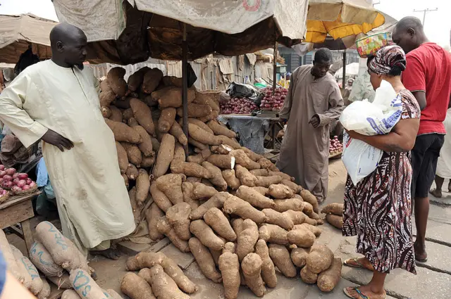 A woman tries to buy yam but vendor complains of low patronage because of hike in pump price in Lagos