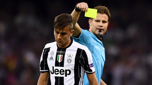 Paulo Dybala of Juventus is shown a yellow card